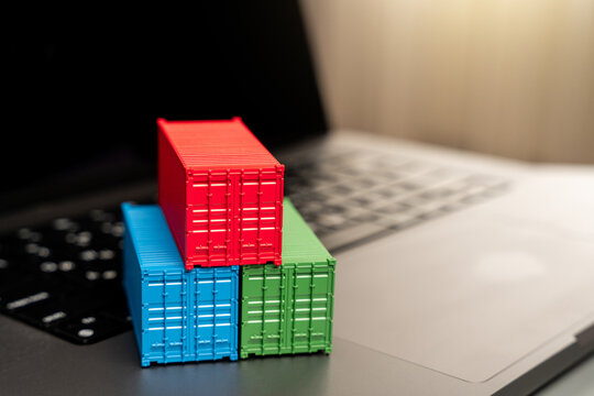 Ship container on laptop keyboard. Trade, economics and transport industry. Production of containers. Import or export. Registration of deliveries and transportation with sea transport operators.