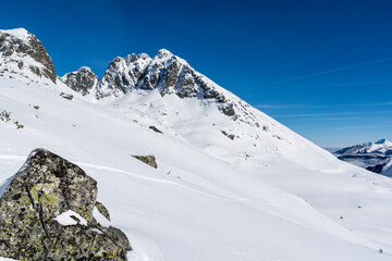 A view of a popular mountain hiking destination in the Polish Tatra Mountains, i.e Kozi Wierch (Kozi vrch, Goat Peak). Winter scenery. - 740592364