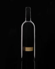 Isolated bottle of red wine on black background with blank label