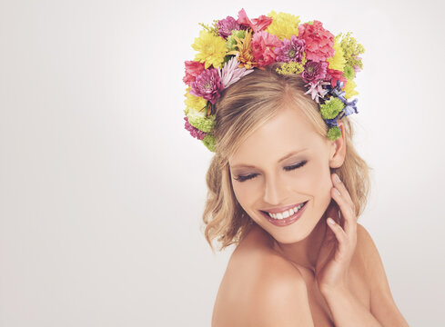 Woman, face and flowers on crown in studio with makeup and happiness for cosmetics, beauty and skincare. Spring aesthetic, model and floral headband with mockup space and wellness on white background