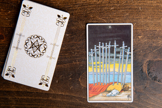 London, UK: 4 January, 2024: Minor Arcana - Ten of Swords of Tarot Card of Rider Waite deck on wooden background