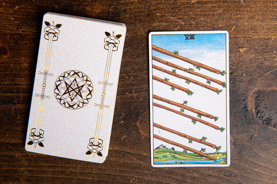 London, UK: 4 January, 2024: Minor Arcana - Eight of Wands of Tarot Card of Rider Waite deck on wooden background