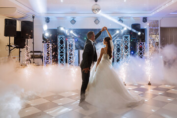 the wedding of the bride and groom in an elegant restaurant with great light and atmosphere. The first dance of the bride and groom. - obrazy, fototapety, plakaty