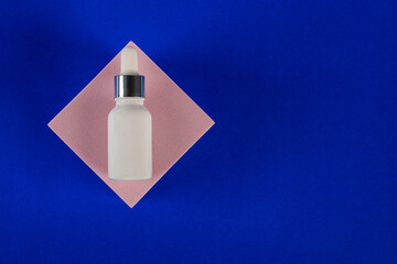 Plastic white tube for cream or lotion. Skin care or sunscreen cosmetic with stylish props on blue background 