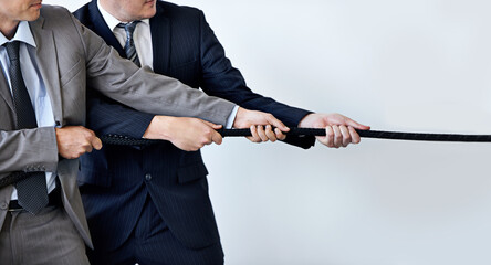 Hands, partnership and tug of war with businessmen in studio for collaboration, competition or...