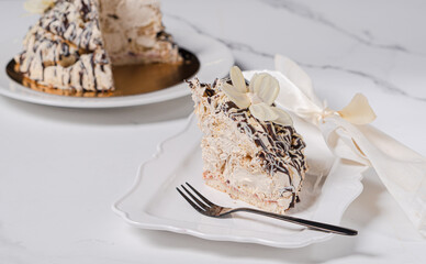 Piece cut from creamy chocolate cake on white background