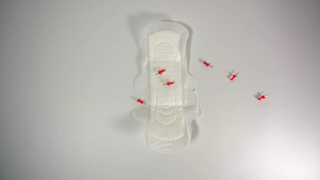 red needles falling on the pad, opened pad, pad test, women's problems, menstrual cycle
