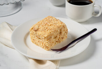 Cake with puff pastry and custard on a white plate on a light table