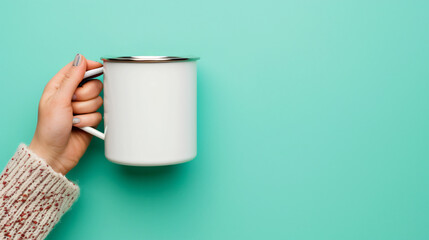 Woman's hand holding a metal white thermal mug.