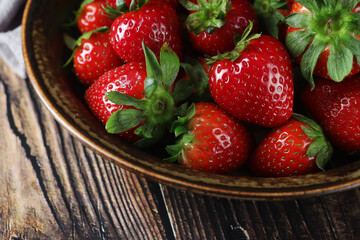 A bowl with ripe bright strawberry in rustic style