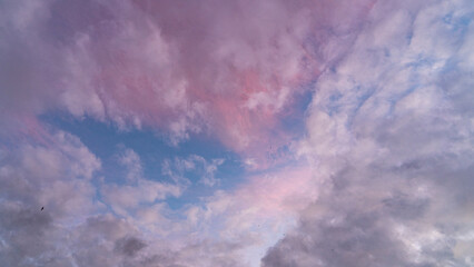 Gün batımı mavi gökyüzünde açık pembe bulutlar. Bulutların pastel renkleri, gün doğumu...