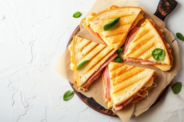 Top view of a homemade ham and cheese sandwich on a cutting board White backdrop with available space