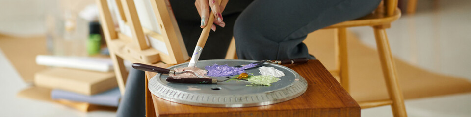 Closeup image of artist mixing oil paints on palette