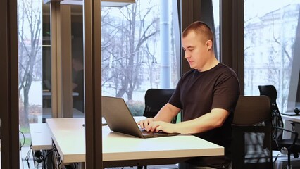 Businessman is working at ergonomic standing workstation in coworking office. Business concept. An IT specialist typing on laptop. SEO manager. A successfull result of online meeting. Overtime work