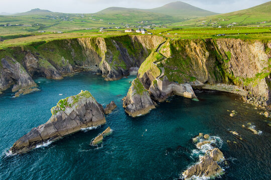 Dunquin or Dun Chaoin pier, Ireland's Sheep Highway. Aerial view of narrow pathway winding down to the pier, ocean coastline, cliffs. Popular location on Slea Head Drive and Wild Atlantic Way.