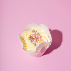 Sweet dessert cupcakes with cream and with pearl decor on pink background
