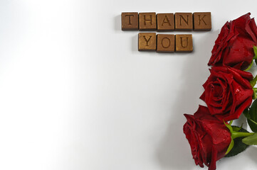 the inscription on the chocolates, thank you. roses on a white background with copy space