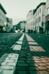 Bicycle orange line paint over street in the city center. White and orange  line road marking for car and bicycle. Old italian street in city center with white road marks.