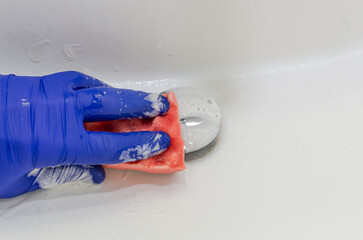 Housekeeper cleans bathroom fixtures with household chemicals