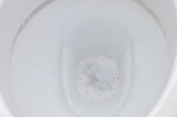 Housekeeper cleans bathroom fixtures with household chemicals