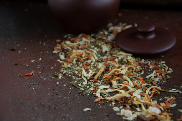 Dried vegetable spices for soup are scattered on a dark table