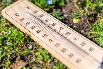 Thermometer in the grass. Rising temperatures and global warming.