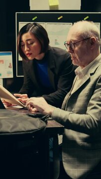 Vertical Video Team members cross reference data to track down potential suspect, using archived records and forensic evidence reports. Officers uncover crucial information to help solve legal case