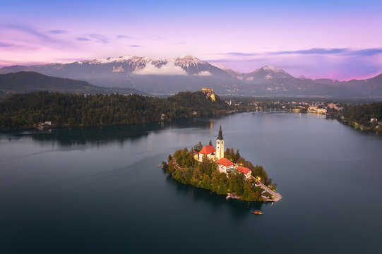 Elevated view with panoramic blue hour dusk night of Lake Bled Island Blejsko jezero with Bled city lights and Julian alps in the background, Bled, Upper Carniola, Slovenia