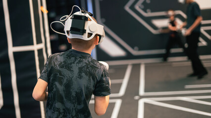 A young boy wearing a virtual reality headset with the number 14 on it