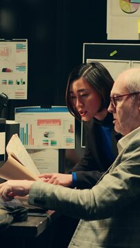 Vertical Video Team members cross reference data to track down potential suspect, using archived records and forensic evidence reports. Officers uncover crucial information to help solve legal case