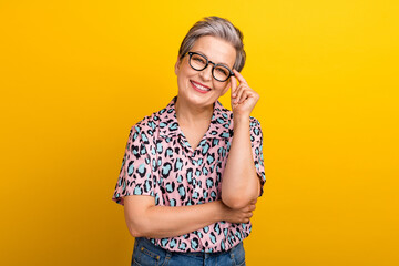 Photo portrait of lovely senior lady touch specs cheerful manager dressed stylish leopard print garment isolated on yellow color background
