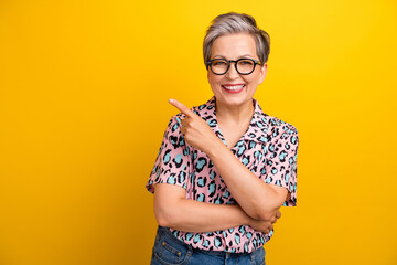 Photo portrait of attractive pensioner woman point empty space dressed stylish leopard print...