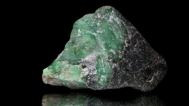Raw Uncut Brazilian Emeralds sample rotating slowly against a black background.