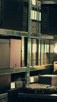 Vertical Video Private investigator organizes archived files for easy access, searching for old file cases to cross reference data. Law enforcement agent looking for classified folders in archive room