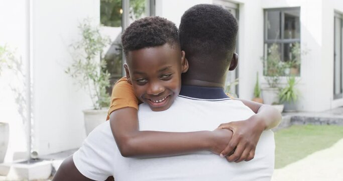 African American father and son share a warm hug outdoors