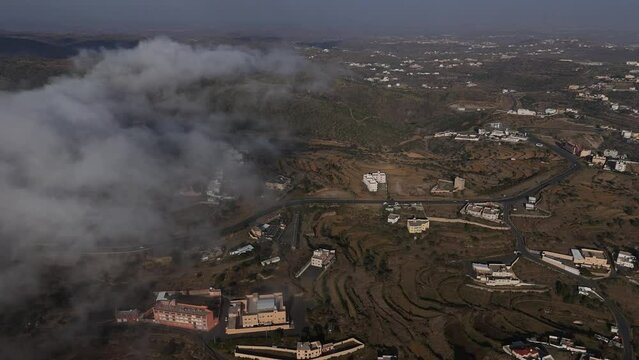 Aerial approaching car stopped near road, Abha, Saudi Arabia. Descending