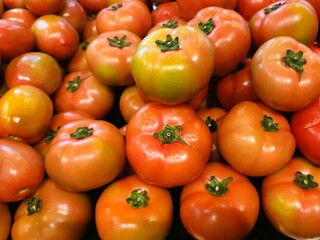Fresh organic red tomatoes are being displayed in a supermarket.