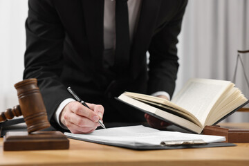 Lawyer working with documents at table indoors, closeup