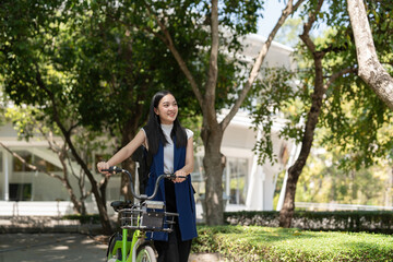 Asian businesswoman in bicycle go to work at office. Bike commuting, happy businesswoman using eco transport, Concept of eco lifestyle