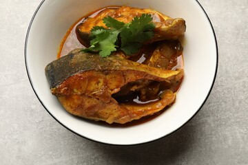 Tasty fish curry on light grey table, closeup. Indian cuisine