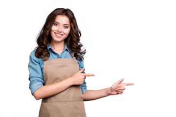 Nice cute stylish positive lovely sweet winsome attractive brunette caucasian girl, barista with wavy hair in casual denim shirt and apron, pointing two fingers aside, isolated over grey background