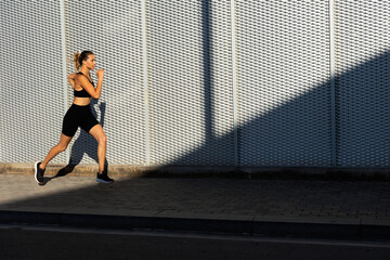 Fototapeta na wymiar Healthy young woman on morning run. Beautiful fit woman jogging outside.