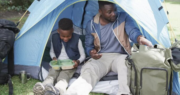 African American father and son enjoy camping outdoors