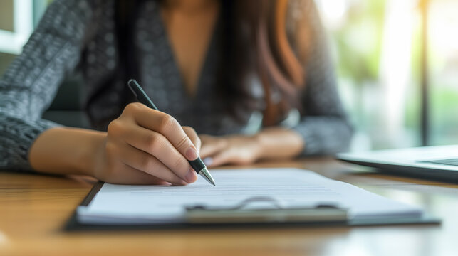Un femme en train de signer un document.