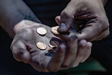 Conceptual image: poverty, hunger, injustice and social inequality. A man counts coins to buy food.