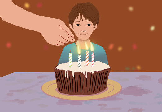 Young boy with lit birthday candles on cake