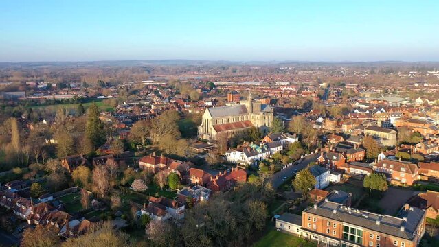 Aerial rising over Romsey UK market town and Romsey Abbey during sunrise 4K