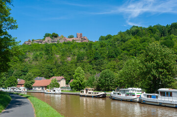 Fototapeta na wymiar Blick zur Ruine Lützelburg bei Lutzelbourg und Hausboote auf dem Rhein-Marne-Kanal. Department Mosel in der Region Lothringen in Frankreich