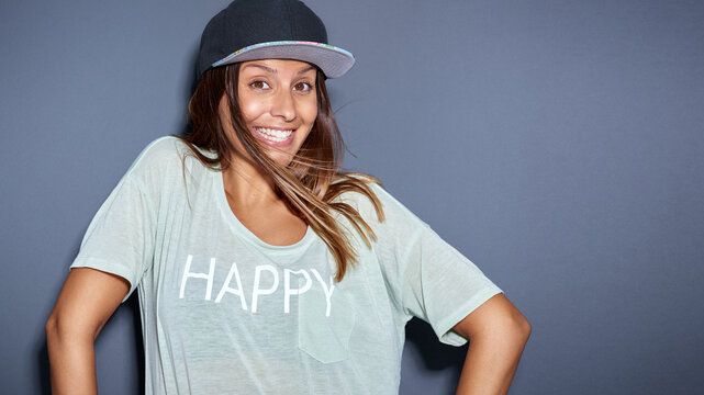 Ethnic woman looking playful at camera while she is wearing a cap