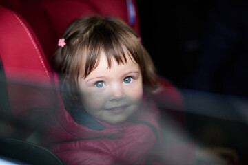 A young girl sits comfortably in a modern car seat, secured and ready for a family adventure on the road.